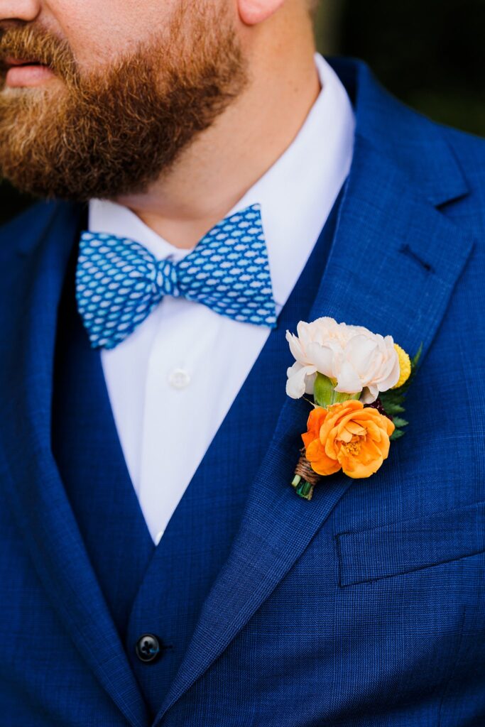 navy groom suit with orange boutionniere