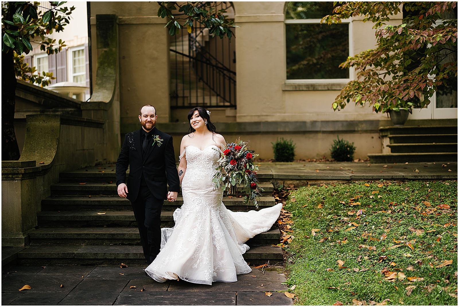A bride and groom laugh on stone steps outside Winterthur.