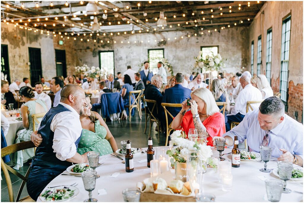 Wedding guests sit down for a reception in  the Mt Washington Mill Dye House.