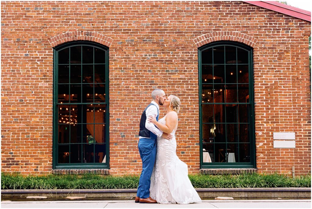 A bride and groom kiss in the courtyard of a Baltimore wedding venue.