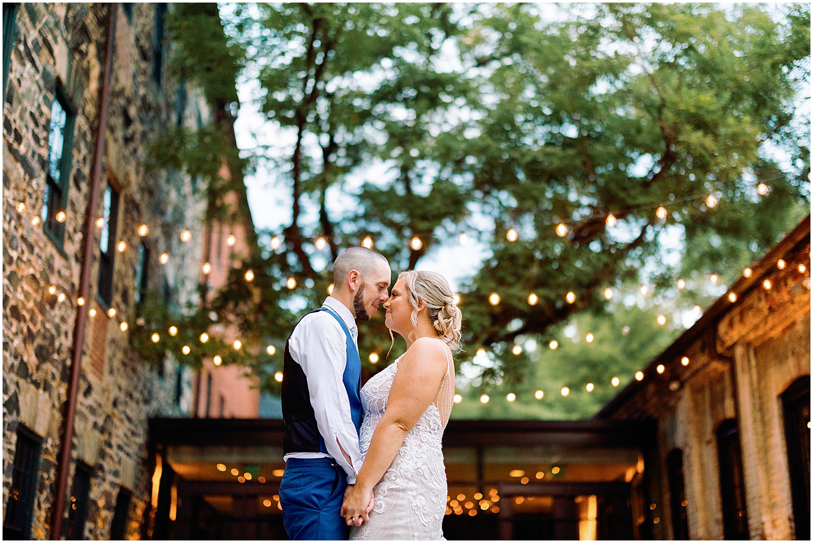 A bride and groom kiss in the courtyard of Mt Washington Mill Dye House.
