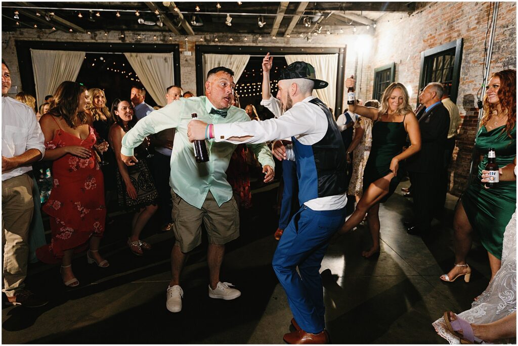 A groom dances with his friends.