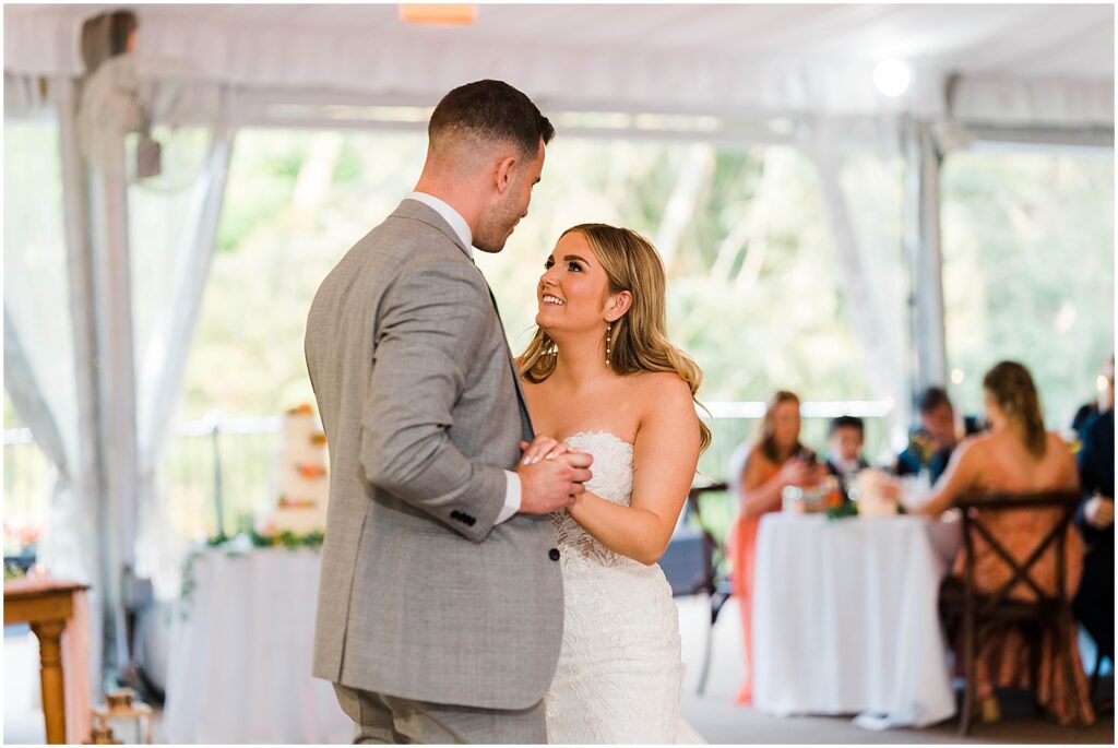 A bride smiles up at a groom during their first dance at Philander Chase Knox Estate.
