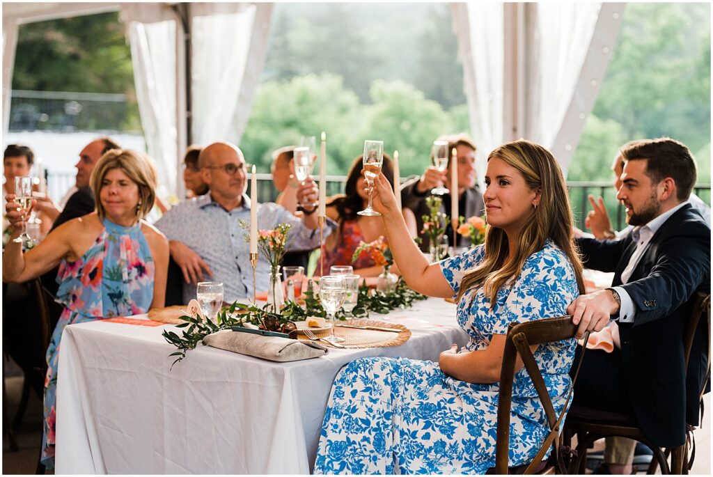 Wedding guests raise their glasses for a toast.