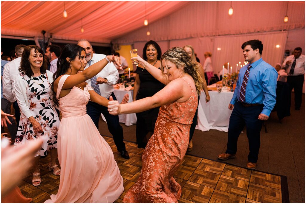 Bridesmaids dance together.