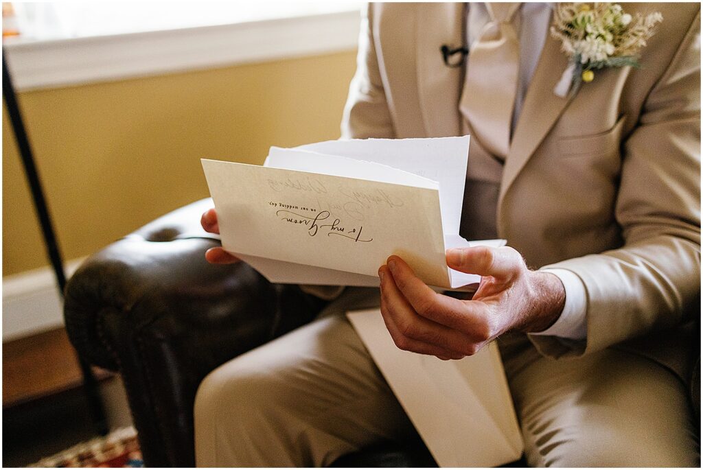 A groom reads a letter in his getting ready suite.