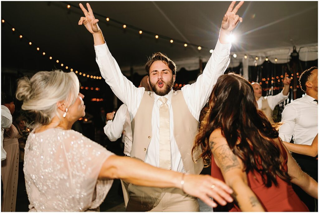 A groomsman jumps onto the dance floor.