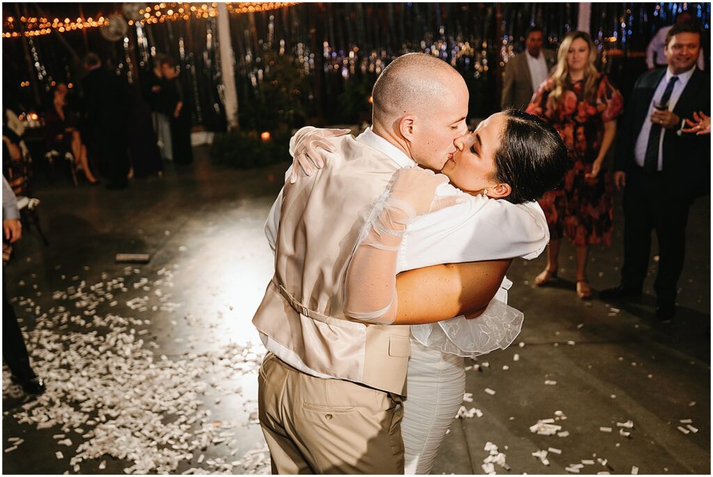 A groom kisses a bride.