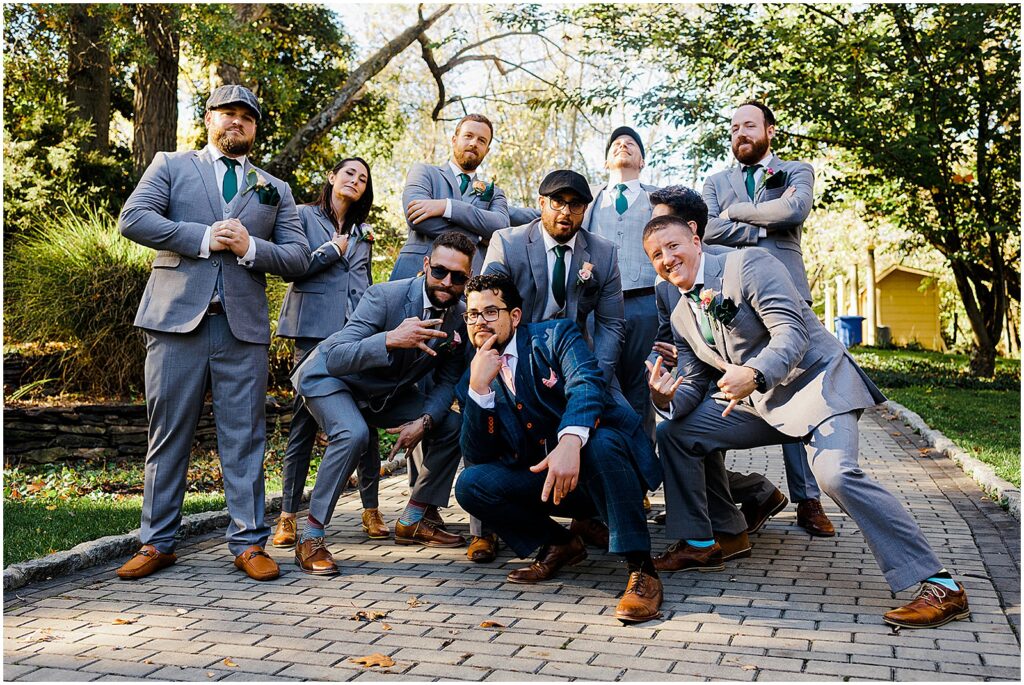 A groom poses with his wedding party on a path.