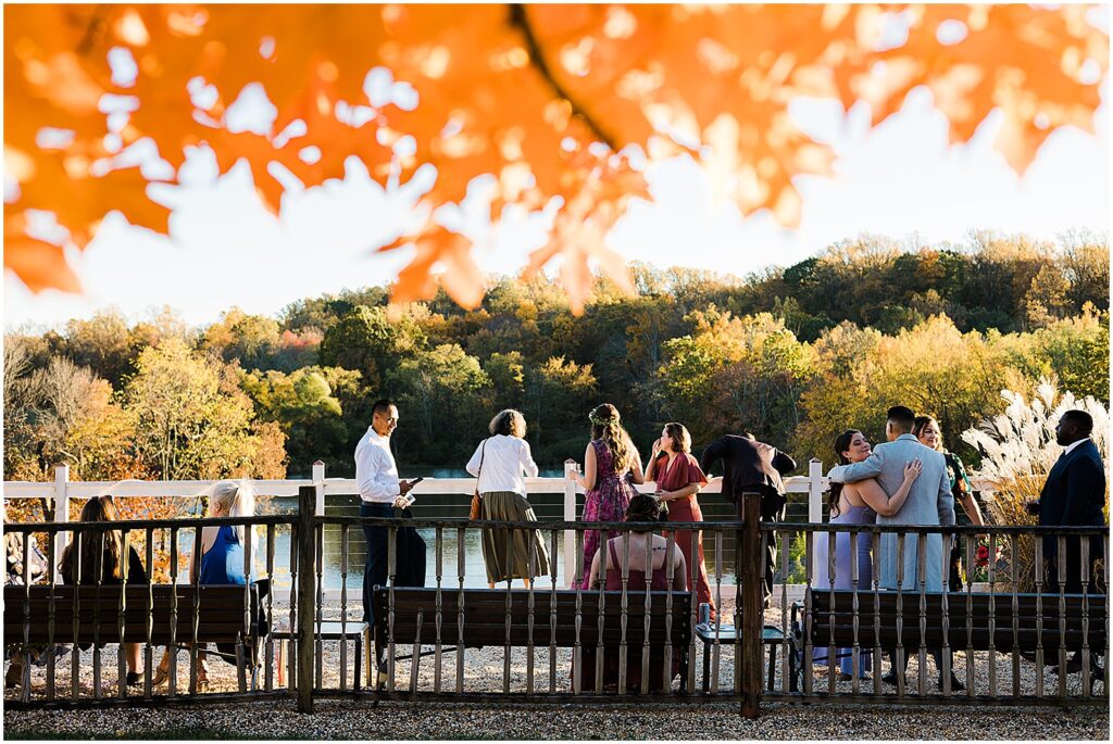 Wedding guests stand on the dock at the Estate at Eagle Lake overlooking the water.