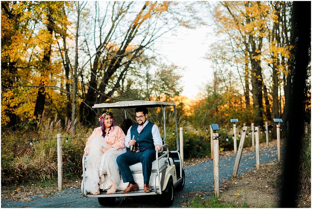 A bride and groom ride a golf part through the Estate at Eagle Lake