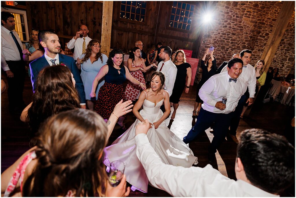 A bride dances surrounded by wedding guests at the Barn at Stoneybrooke.
