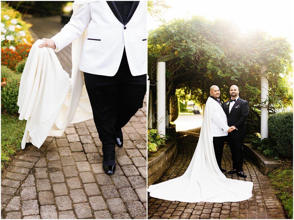 A groom carries their wedding cape as they walk down a path.