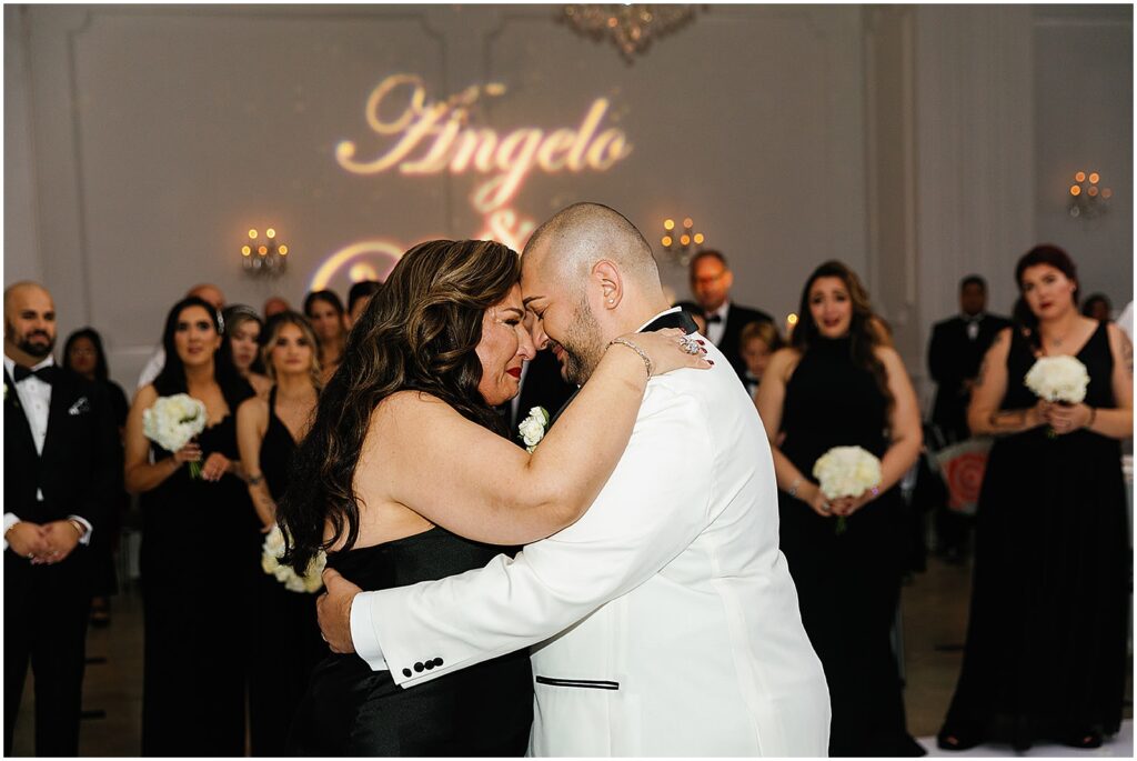 Angelo and their mother touch foreheads while they dance.