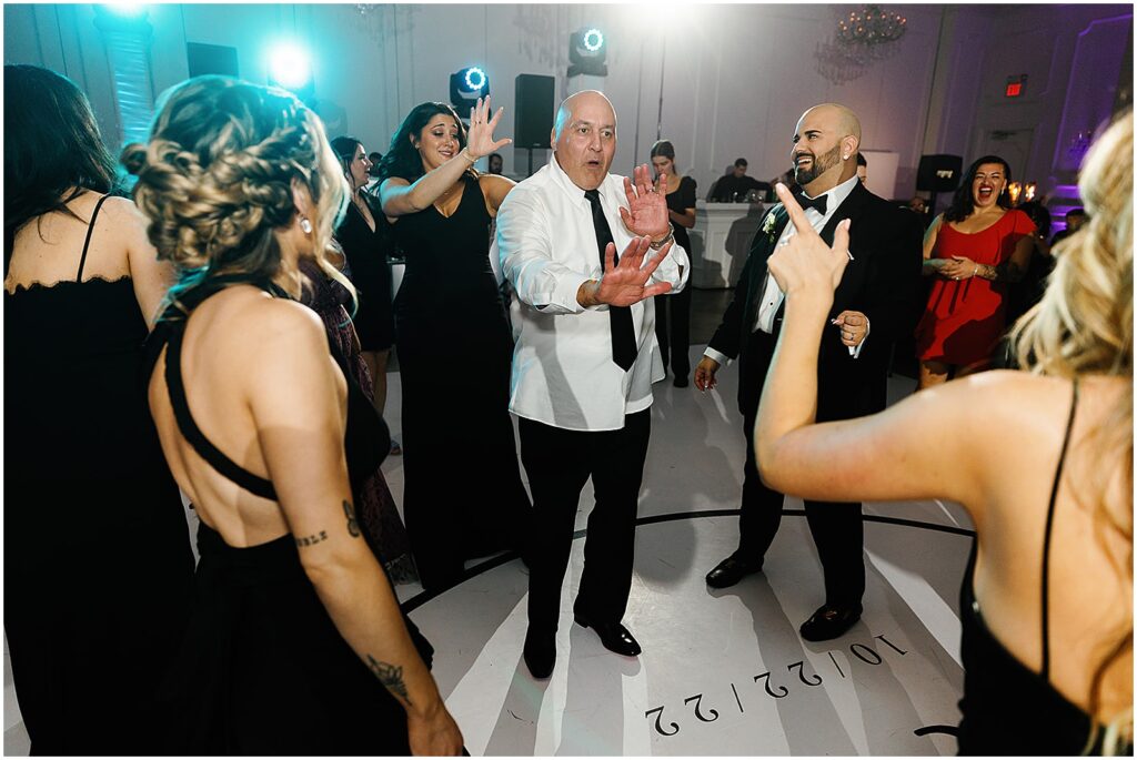 Wedding guests laugh on a custom dance floor.