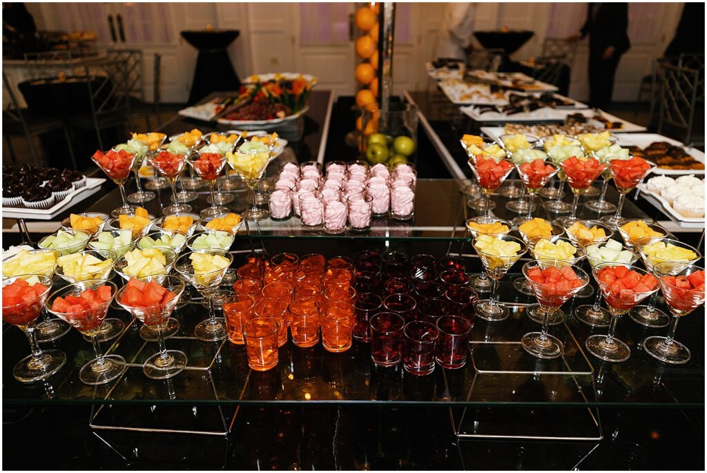Colorful wedding desserts sit on glass displays at a New Jersey wedding reception.