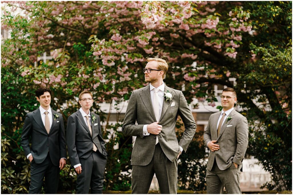 A groom poses with groomsmen for an editorial wedding photo outside the historic smithville inn.
