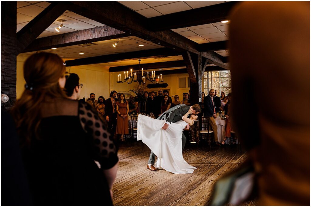 Wedding guests watch as a groom dips a bride during their first dance at the historic smithville inn.