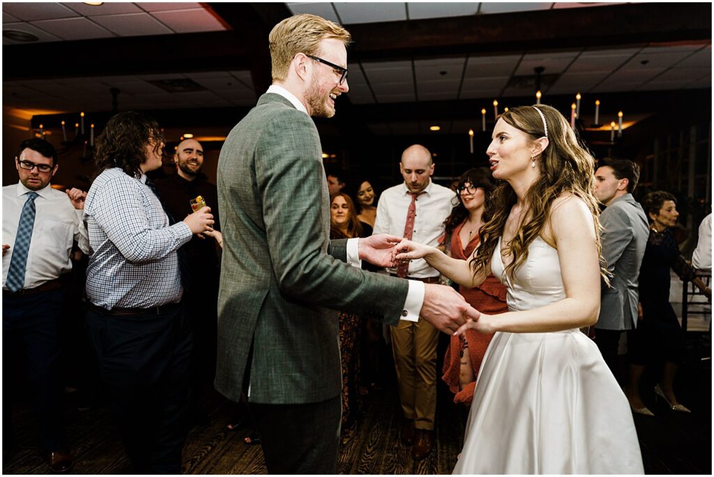 A bride and groom dance among wedding guests at their New Jersey wedding reception.