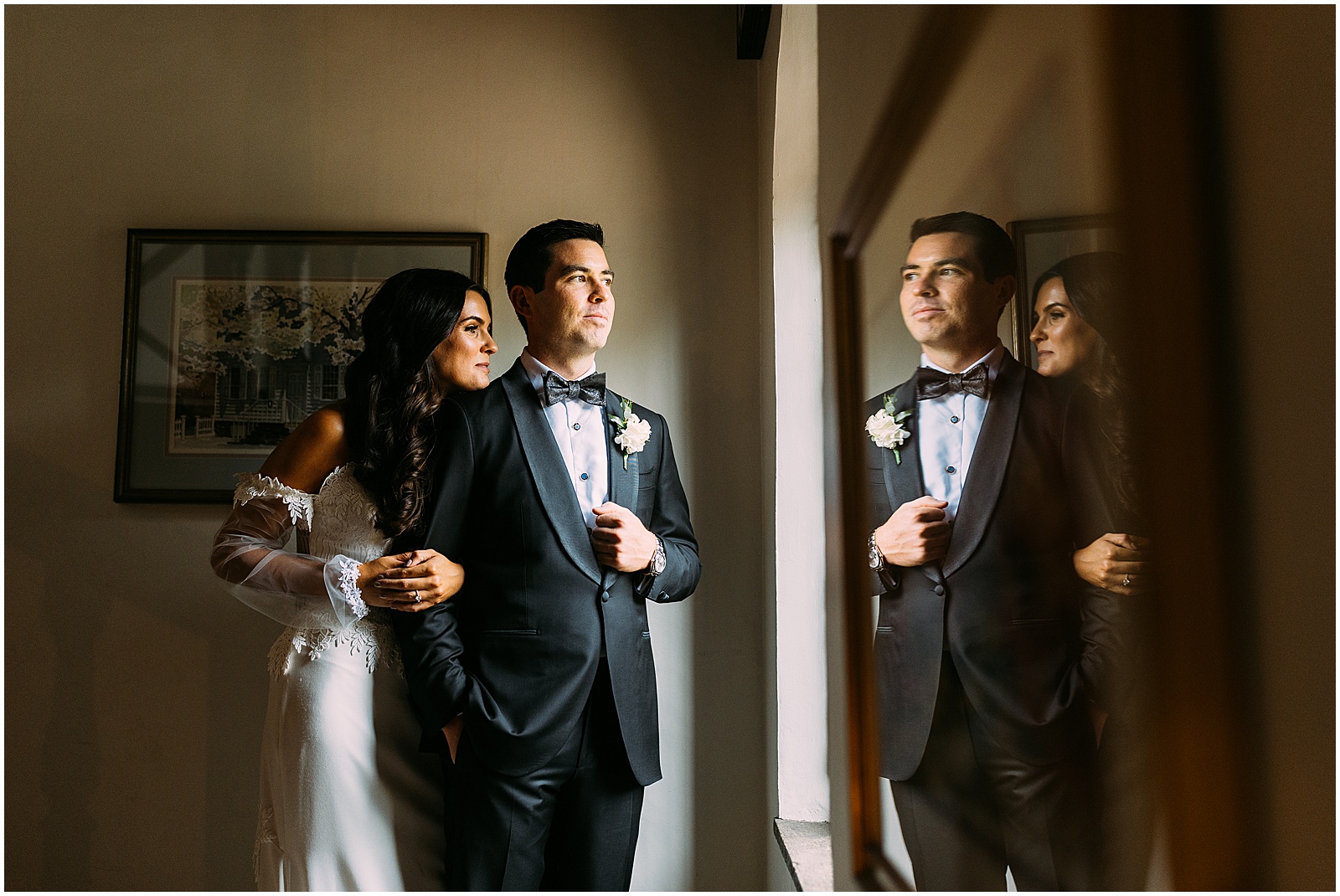 A bride and groom look out a window at their Aldie Mansion wedding.