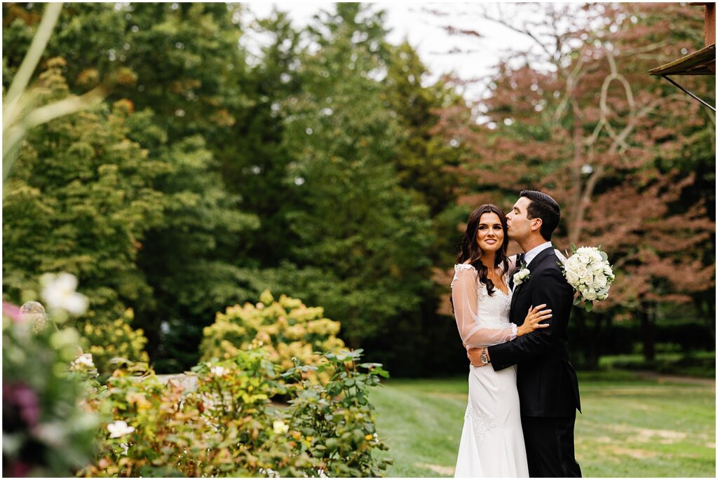 A bride and groom pose for wedding portraits in the garden of Aldie Mansion.