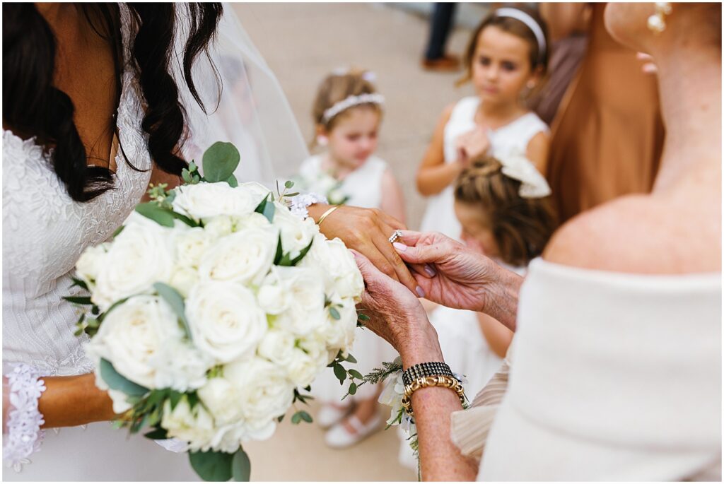 A family member looks at a bride's diamond wedding ring after a Philadelphia wedding.