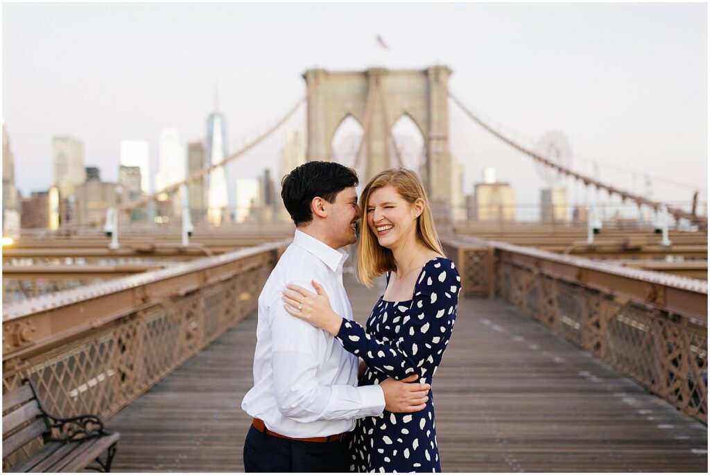 A man and woman embrace in Brooklyn Bridge engagement photos.