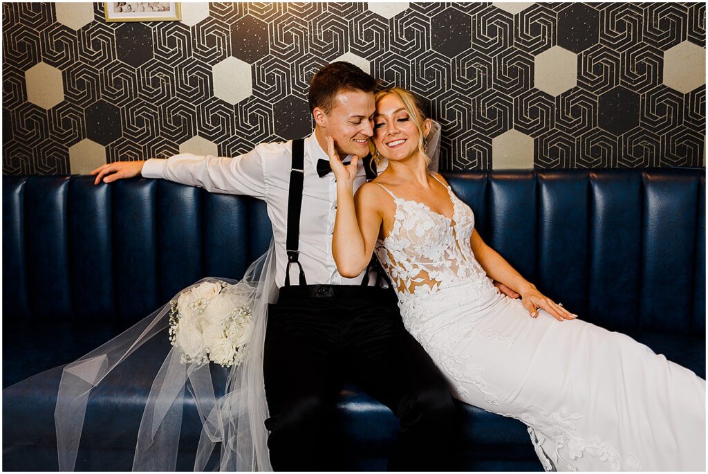 A bride leans against a groom on a blue couch in direct flash wedding photography at a New Jersey wedding.