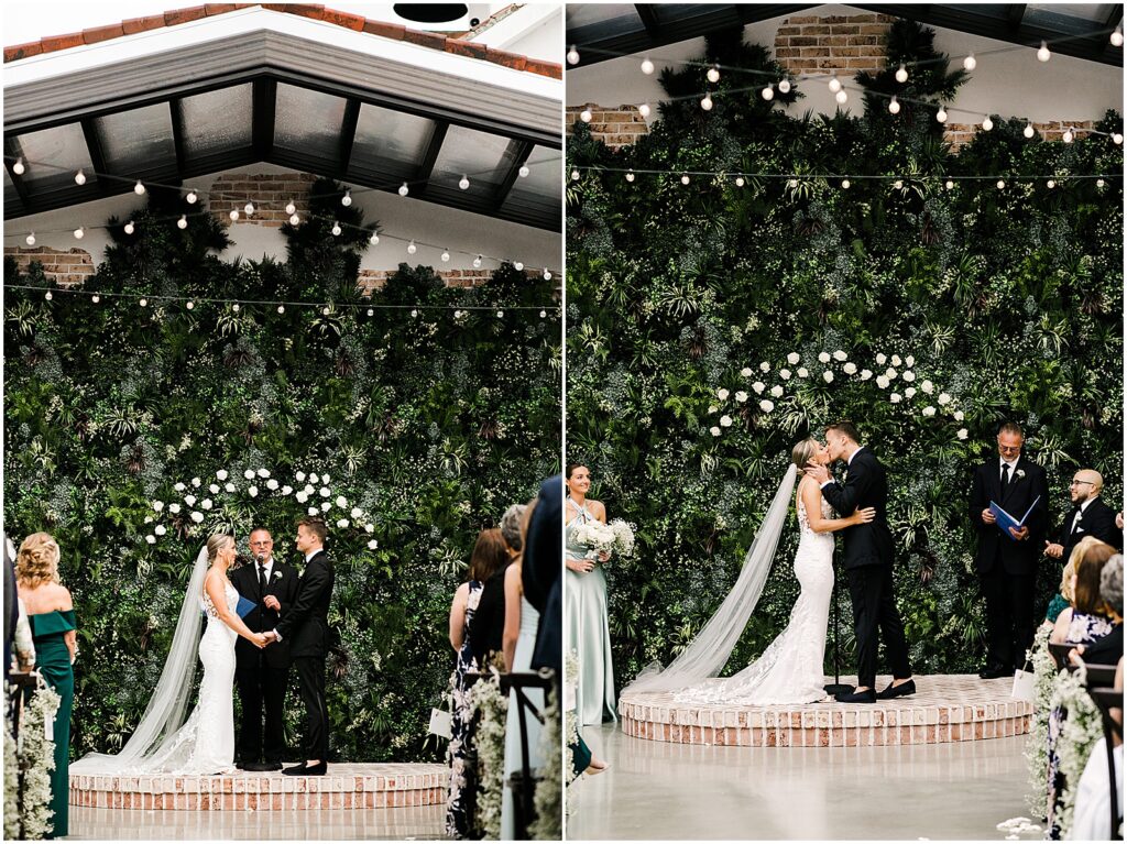 A bride and groom kiss in front of a living wall at the end of their Perona Farms wedding ceremony.