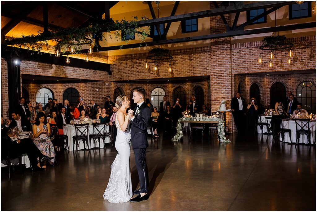 A bride and groom have their first dance in the Refinery at Perona Farms.