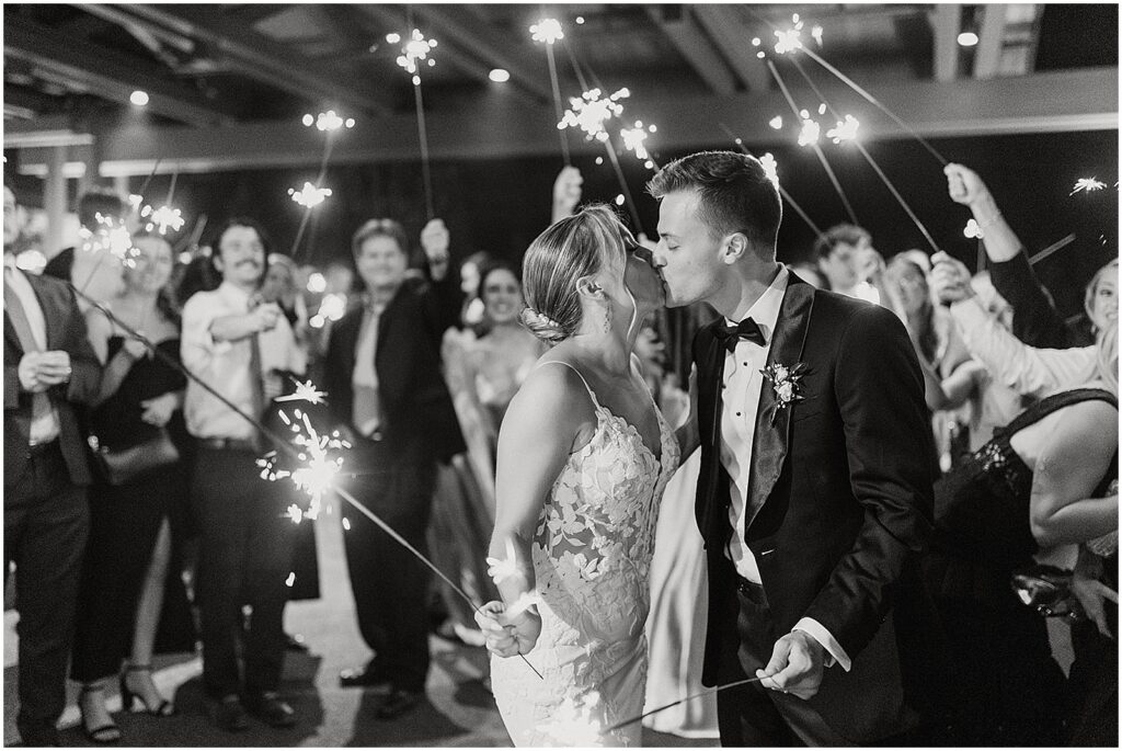 A bride and groom kiss at their sparkler exit from Perona Farms.