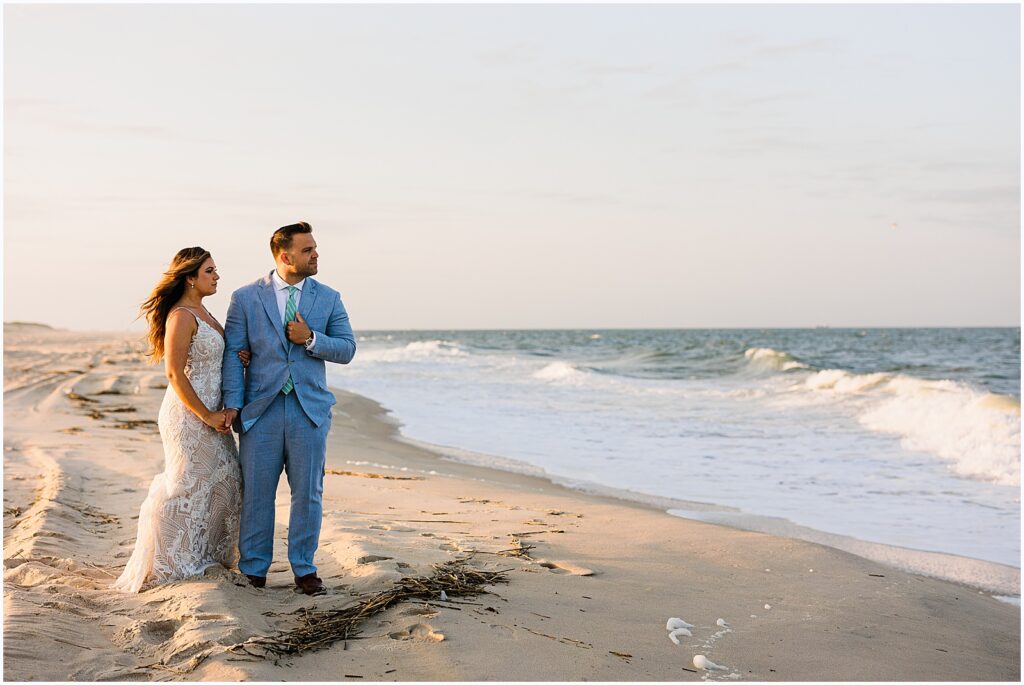 A bride and groom watch the waves at sunset at their Delaware wedding.