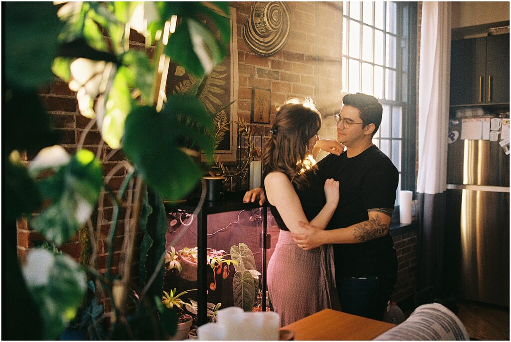 A husband and wife pose for a New Jersey wedding photographer in an industrial apartment.
