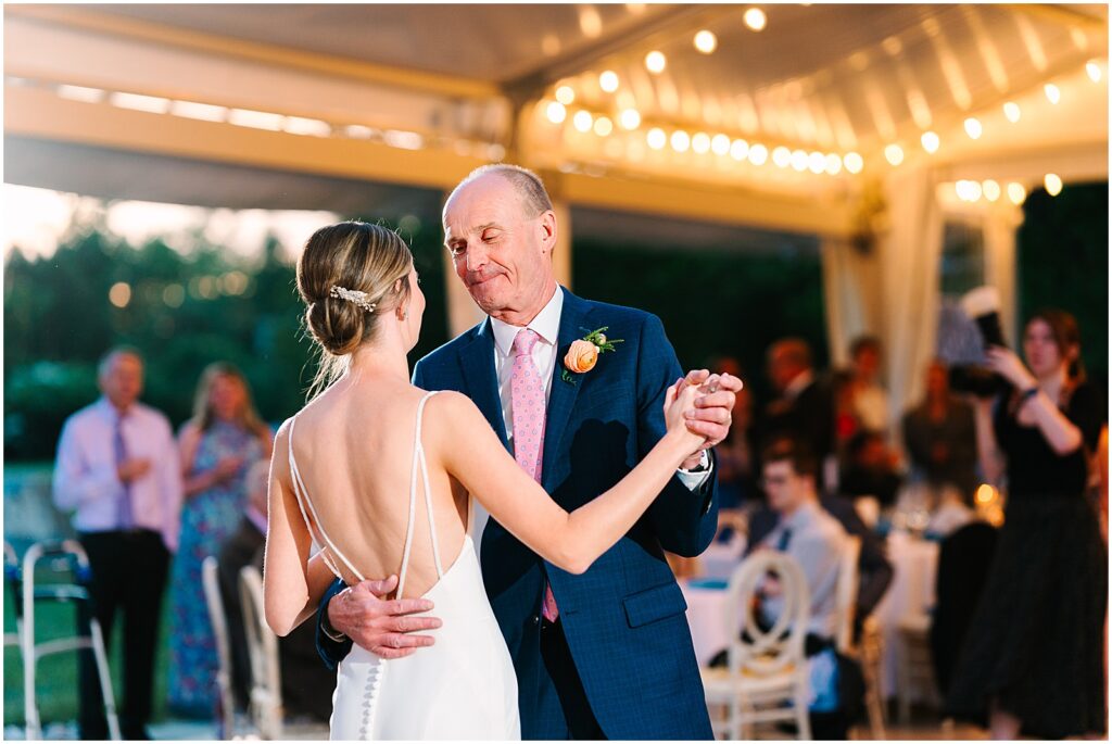 A bride and her father have the father daughter dance.