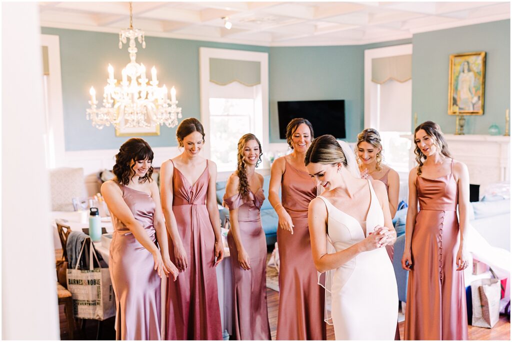 A bride does a first look with bridesmaids at her spring wedding.