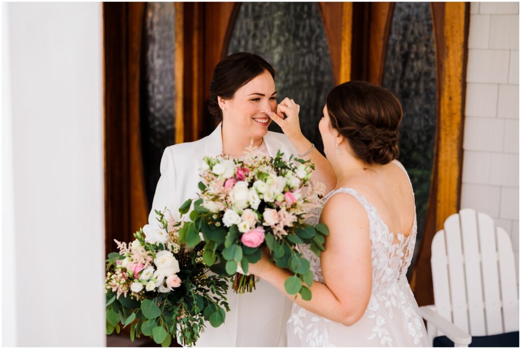 A bride wipes a tear from her wife's face during their first look.