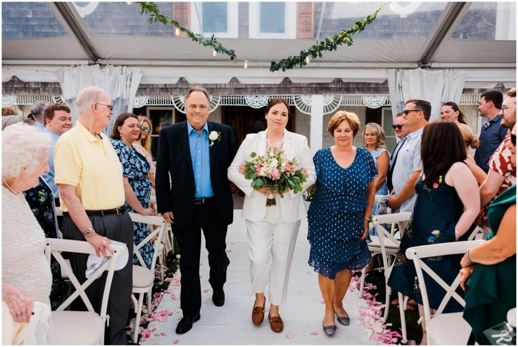 A bride's parents walk her up the aisle at her Addy Sea Historic Oceanfront Inn wedding.
