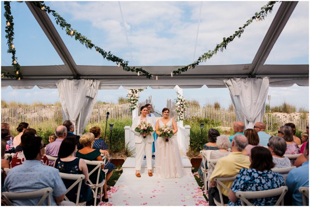 Two brides turn to face their wedding guests at Addy Sea Historic Oceanfront Inn.