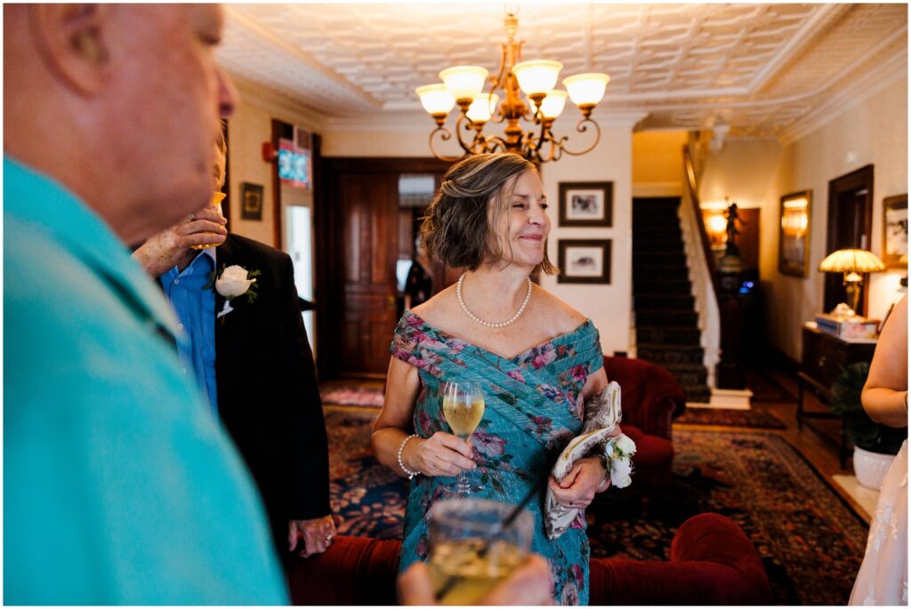 The mother of the bride drinks a cocktail during cocktail hour.