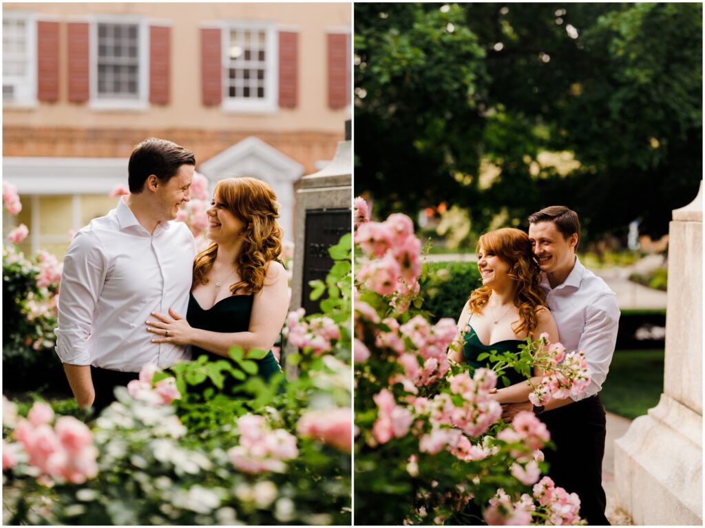 A man and woman pose for creative engagement photos behind a rose bush.