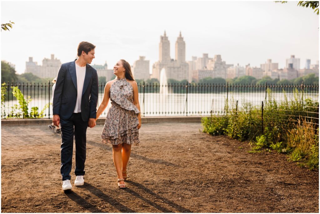 A man and woman walk through Central Park for New York City engagement photos.