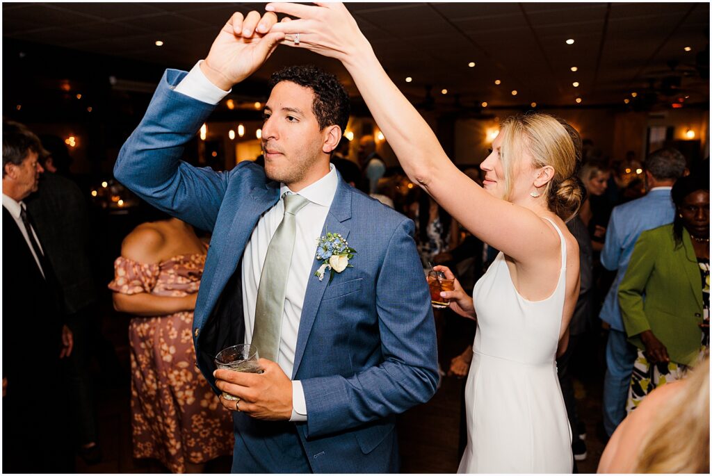 A bride twirls a groom on the dance floor.