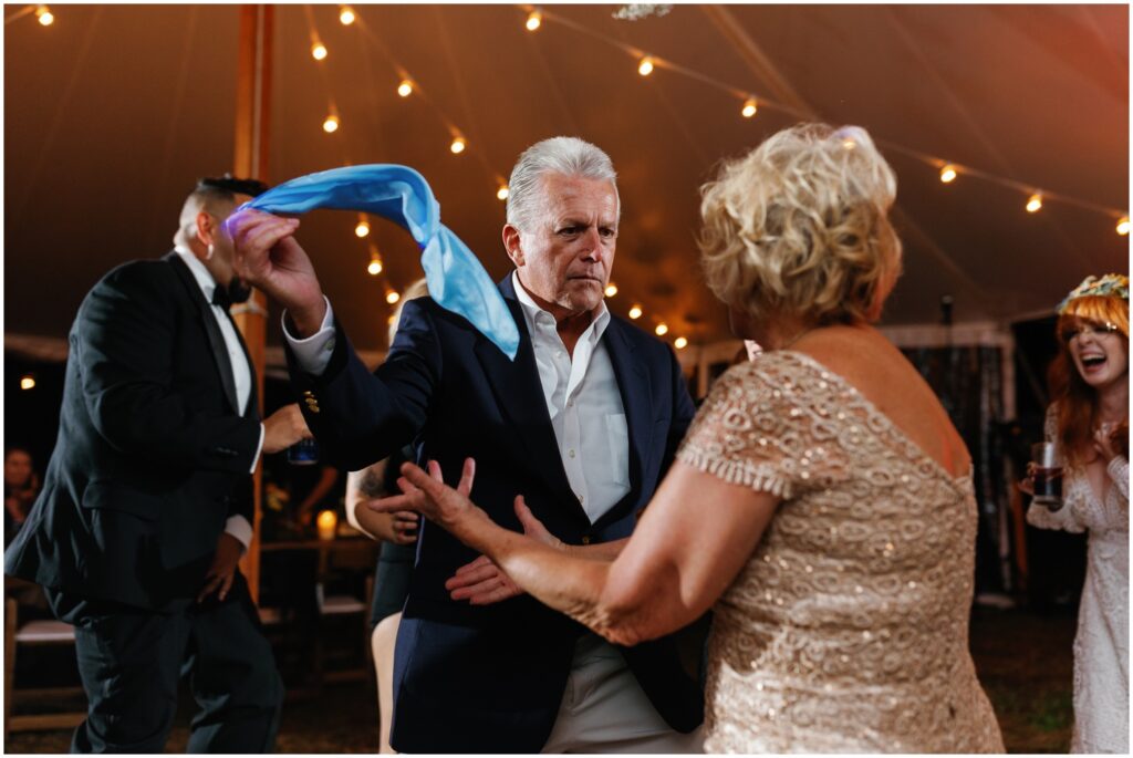 The bride's parents dance with a blue handkerchief.