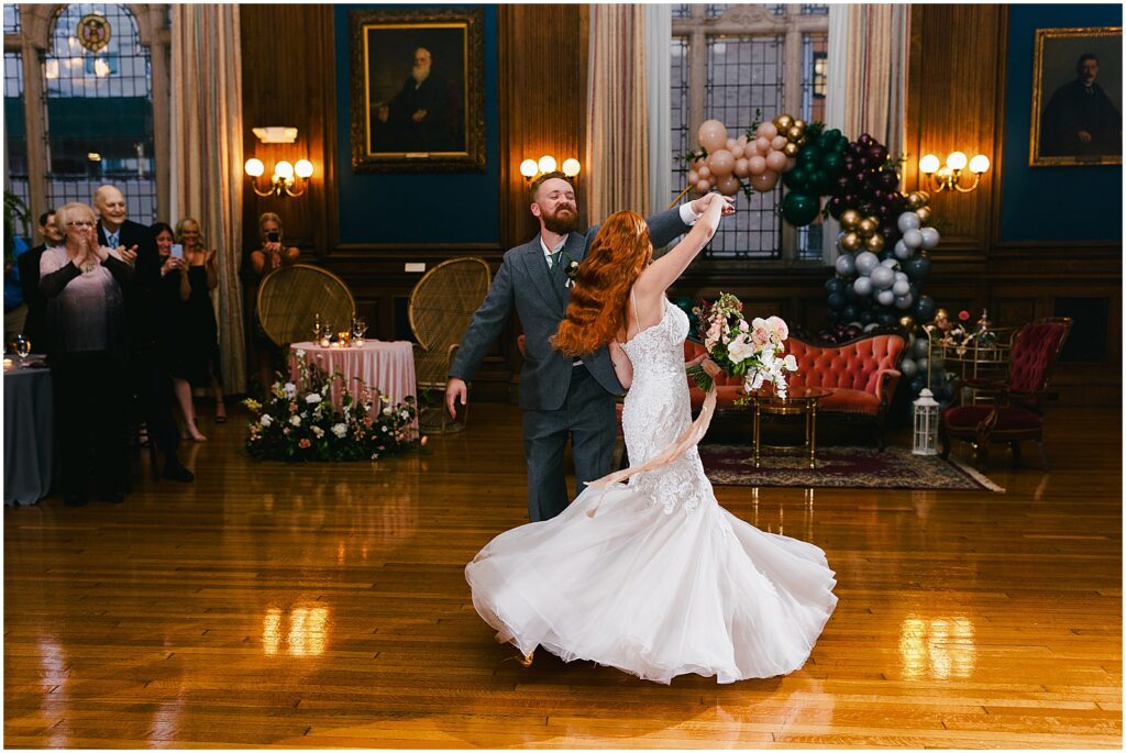 A groom spins a bride for their first dance.