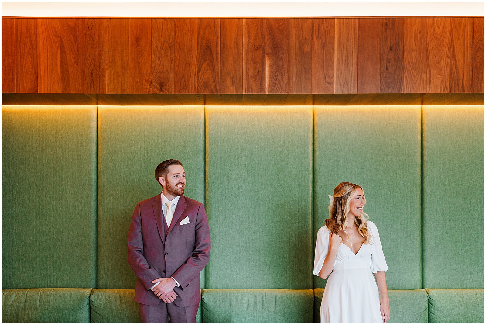 A bride and groom pose against a green wall before their wedding at Porta Asbury Park.