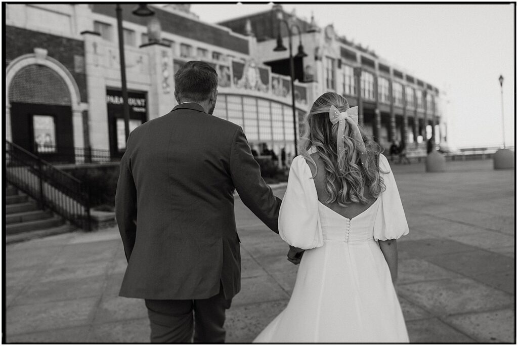 A bride and groom walk towards the Asbury Park Convention Hall.