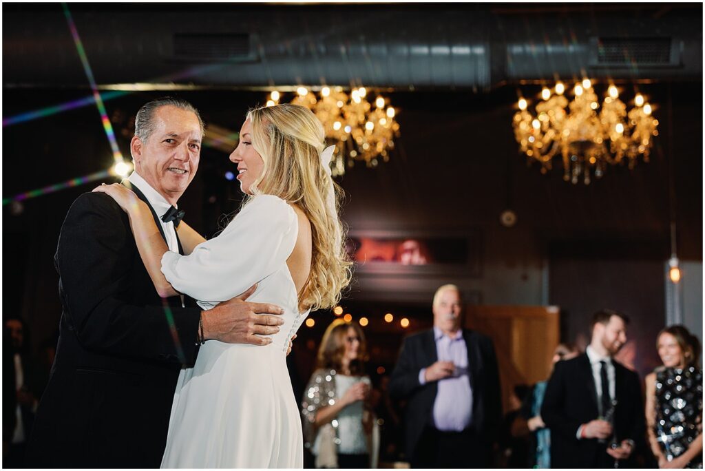 A bride and her father smile during the father-daughter dance.