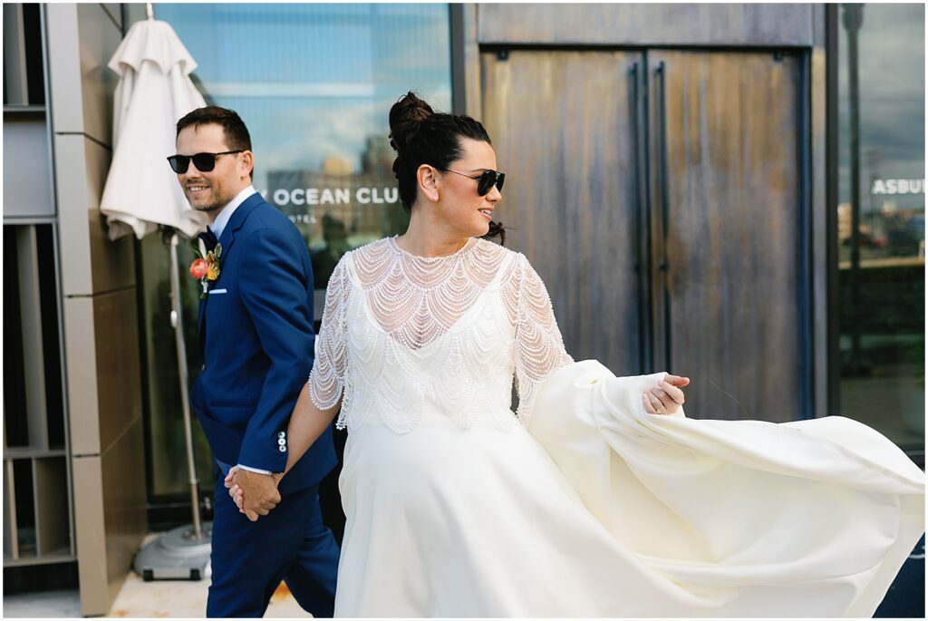 A bride and groom exit an Asbury Park hotel in sunglasses.