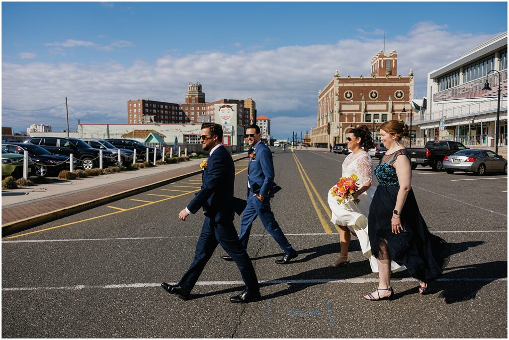 A bride and groom cross the street with their best man and maid of honor in Asbury Park.
