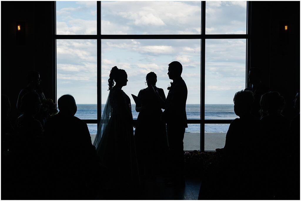 A wedding ceremony is backlit by a sunny window inside Watermark.
